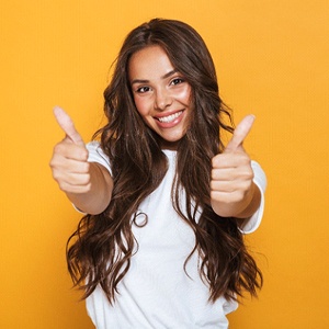 Woman with healthy smile giving thumbs up