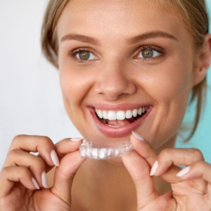 Woman putting in a whitening tray 