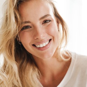 Woman with blonde hair and white teeth smiling