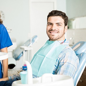 Man smiling in dental chair during consultation