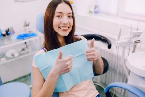 woman giving thumbs up at dentist